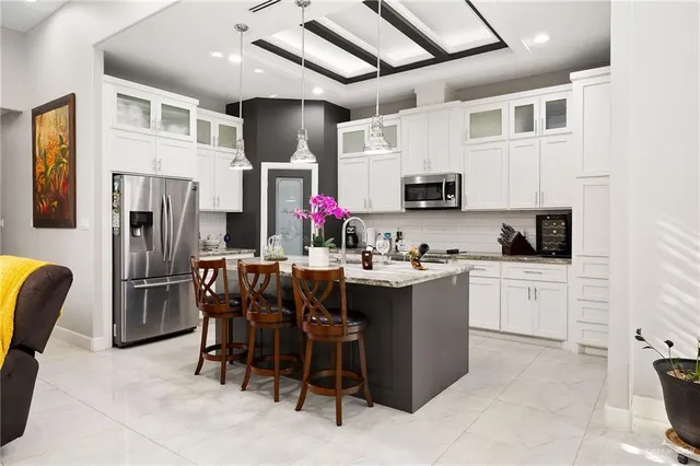 a kitchen with stainless steel appliances kitchen island granite countertop a refrigerator and microwave