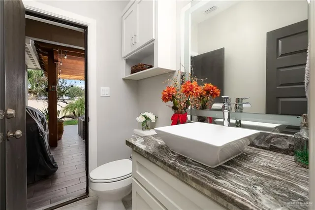 a bathroom with a sink a toilet and a mirror