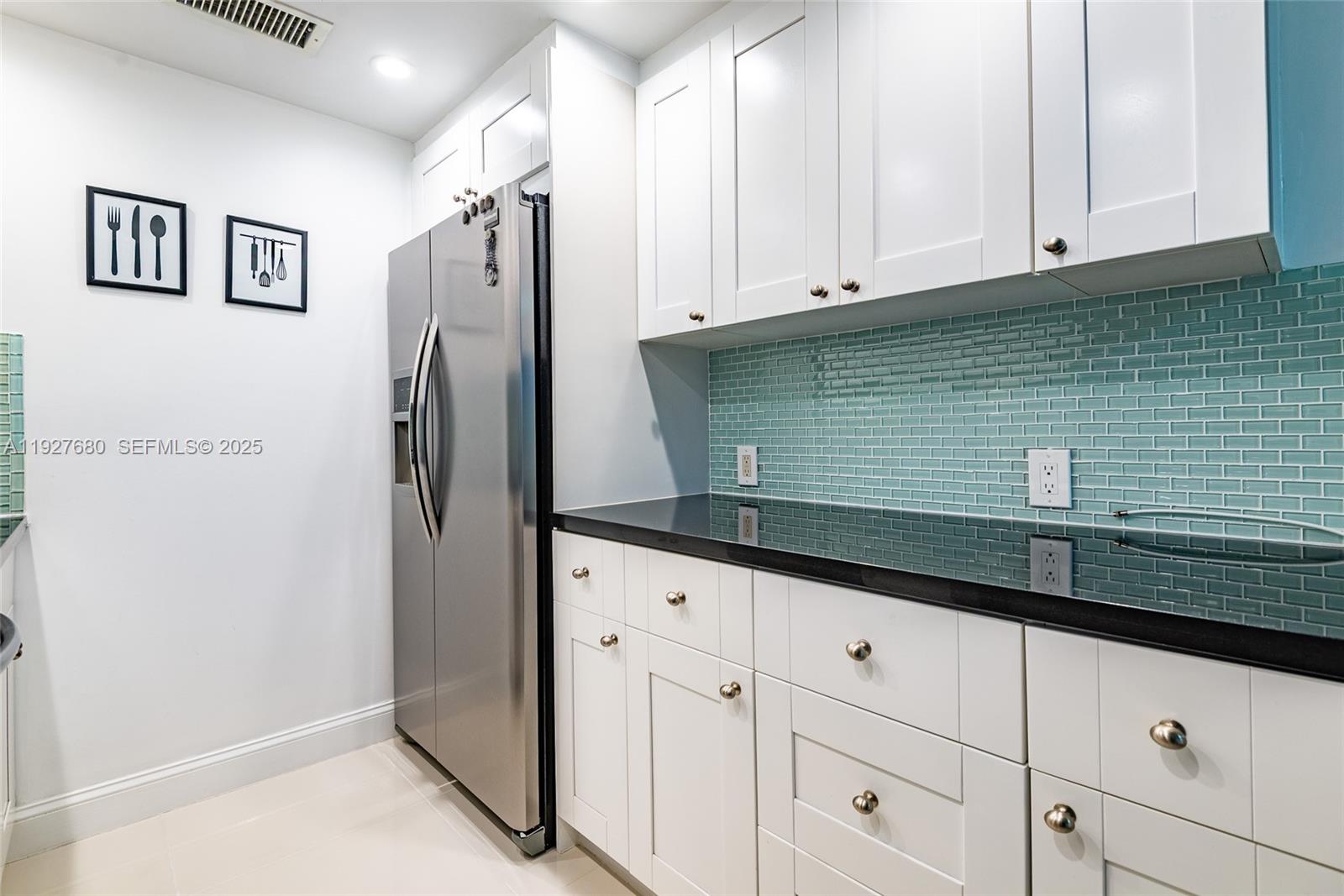 1061 Exeter, Unit 1061D Boca Raton, FL 33434 - Photo 11 of 32 a kitchen with granite countertop a refrigerator and cabinets