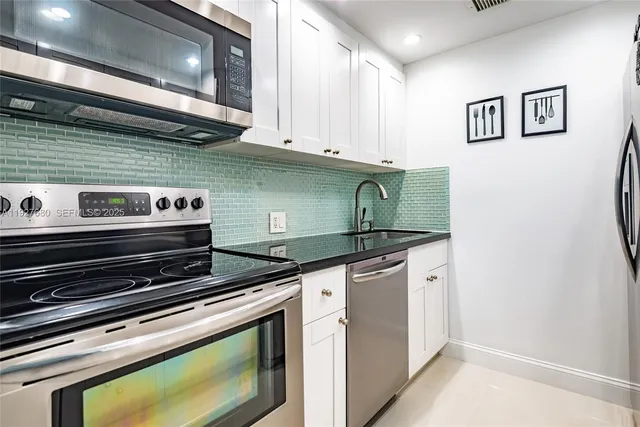 a kitchen with granite countertop a stove and a microwave