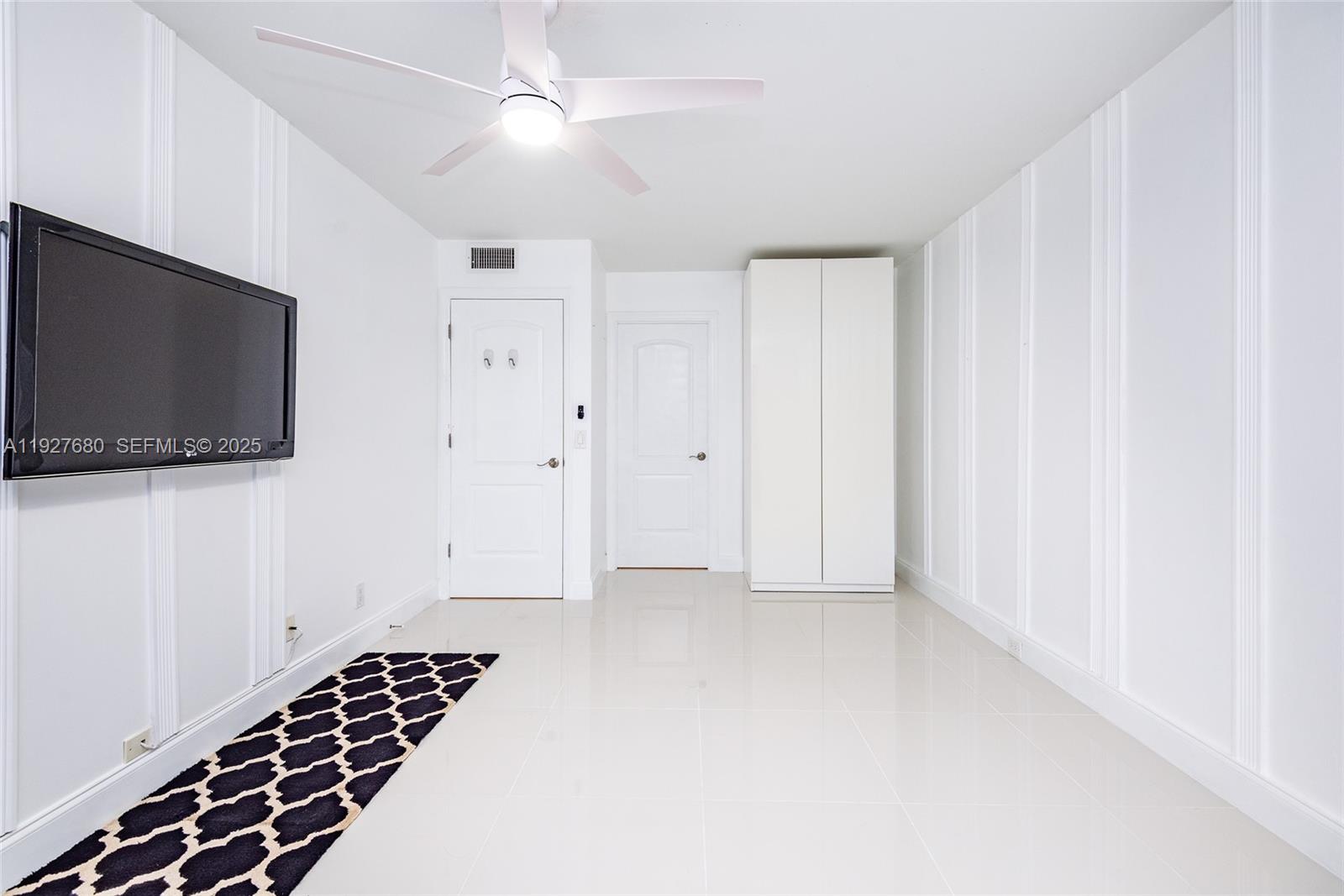 1061 Exeter, Unit 1061D Boca Raton, FL 33434 - Photo 15 of 32 a view of an empty room with a flat screen tv