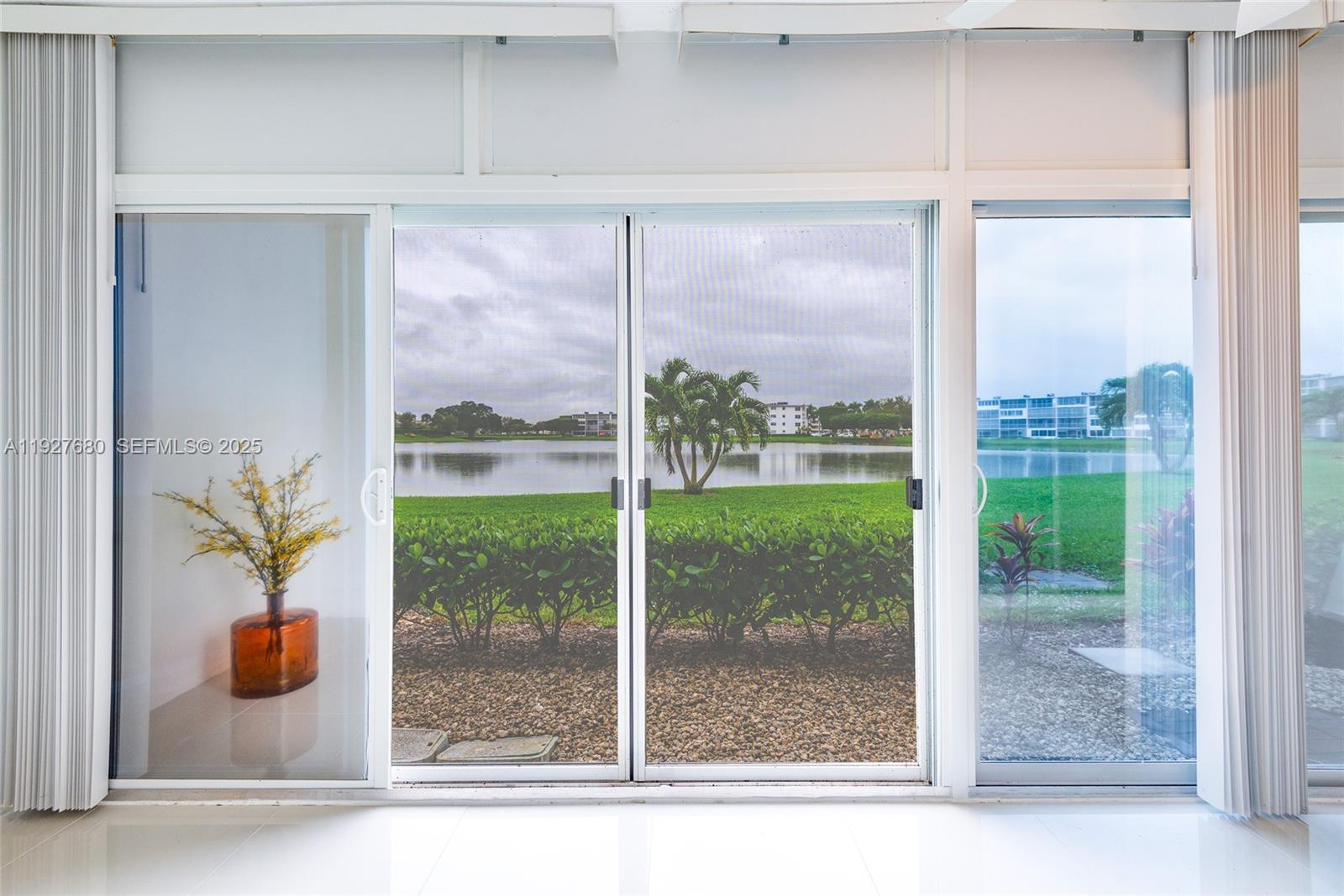 1061 Exeter, Unit 1061D Boca Raton, FL 33434 - Photo 22 of 32 a view of a room that has a sliding door and a porch
