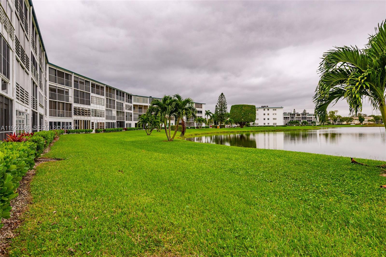 1061 Exeter, Unit 1061D Boca Raton, FL 33434 - Photo 26 of 32 a view of a house with a big yard and palm trees