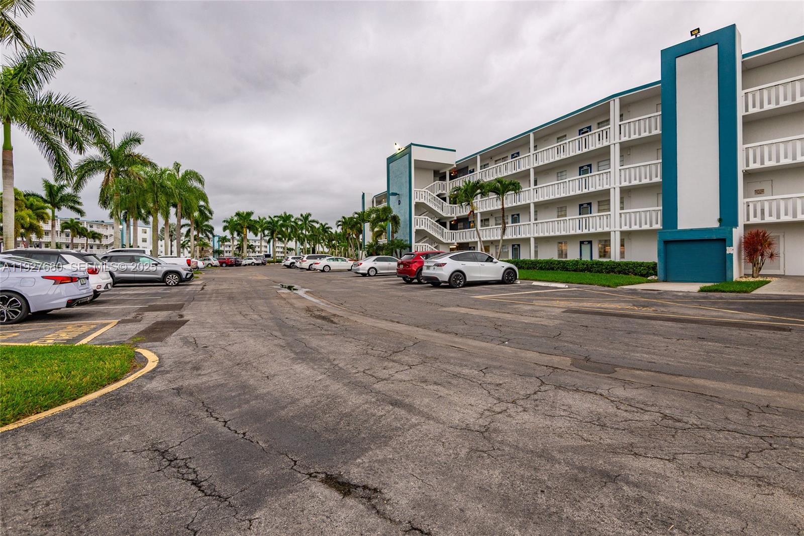 1061 Exeter, Unit 1061D Boca Raton, FL 33434 - Photo 28 of 32 a view of building with cars parked in front of it