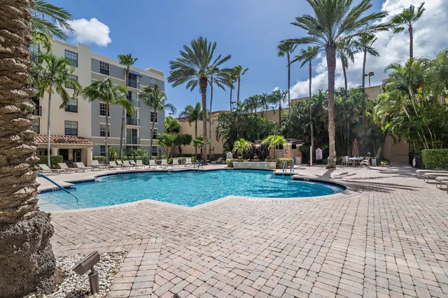 a front view of multi story residential apartment building with yard and green space