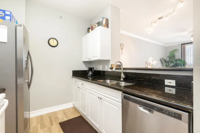 a kitchen with stainless steel appliances granite countertop a refrigerator and a sink
