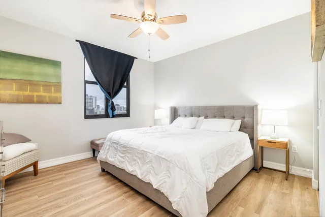 a bedroom with a bed and a painting on the wall