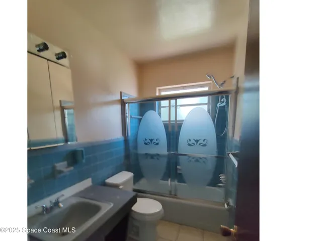 a bathroom with a toilet a sink and shower