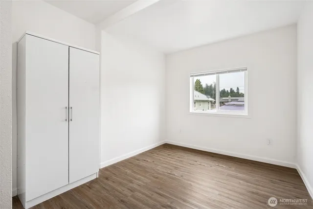 an empty room with wooden floor and window