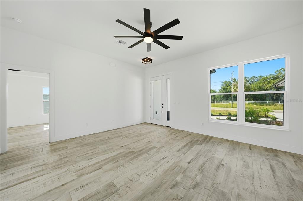8846 Southwest Liverpool Road Arcadia, FL 34269 - Photo 14 of 49 an empty room with wooden floor fan and windows