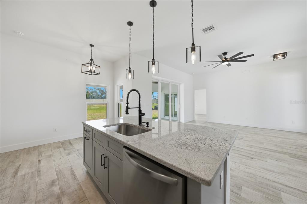 8846 Southwest Liverpool Road Arcadia, FL 34269 - Photo 6 of 49 a kitchen with stainless steel appliances granite countertop a sink a stove and a wooden floor