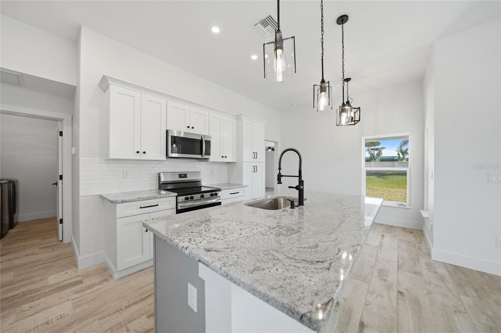 8846 Southwest Liverpool Road Arcadia, FL 34269 - Photo 10 of 49 a kitchen with a sink a counter top space cabinets and stainless steel appliances
