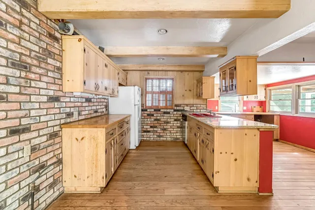 a kitchen with stainless steel appliances granite countertop a stove and a wooden floors