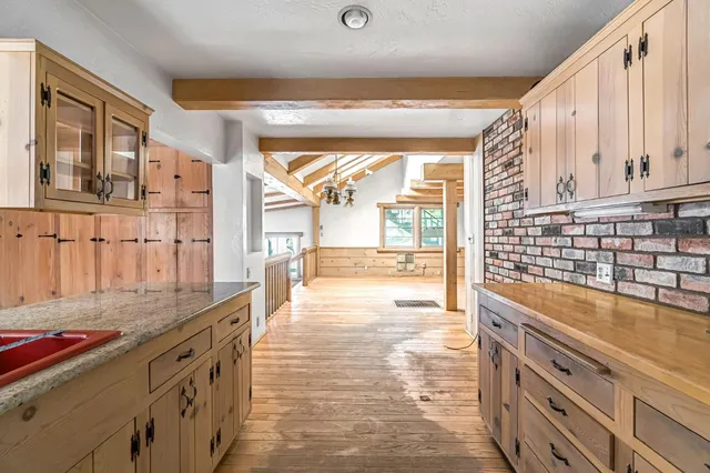 a kitchen with stainless steel appliances kitchen island granite countertop a stove a sink and white cabinets