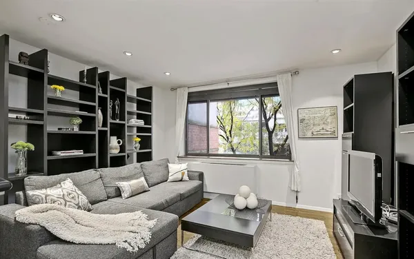 a living room with furniture cabinets and a flat screen tv