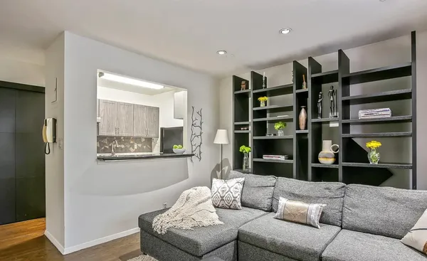 a living room with furniture cabinets and wooden floor