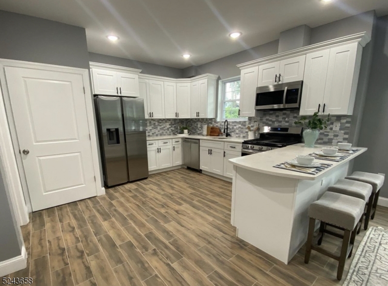 825 Allwood Road, Unit A Clifton, NJ 07012 - Photo 3 of 11 a kitchen with stainless steel appliances a stove refrigerator sink and microwave