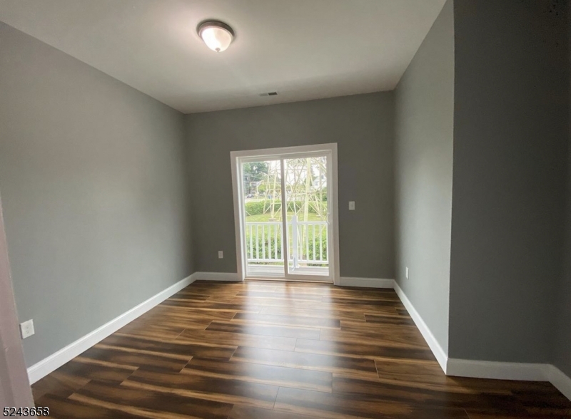825 Allwood Road, Unit A Clifton, NJ 07012 - Photo 6 of 11 a view of an empty room with wooden floor and a window