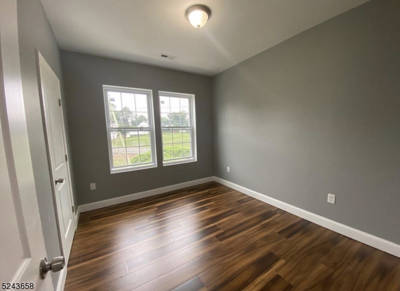 825 Allwood Road, Unit A Clifton, NJ 07012 - Photo 8 of 11 an empty room with wooden floor and windows