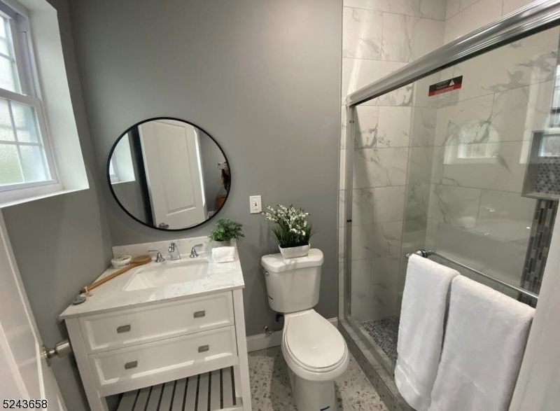 825 Allwood Road, Unit A Clifton, NJ 07012 - Photo 10 of 11 a bathroom with a toilet sink vanity tub and mirror