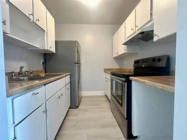 a kitchen with stainless steel appliances a stove a sink and a refrigerator
