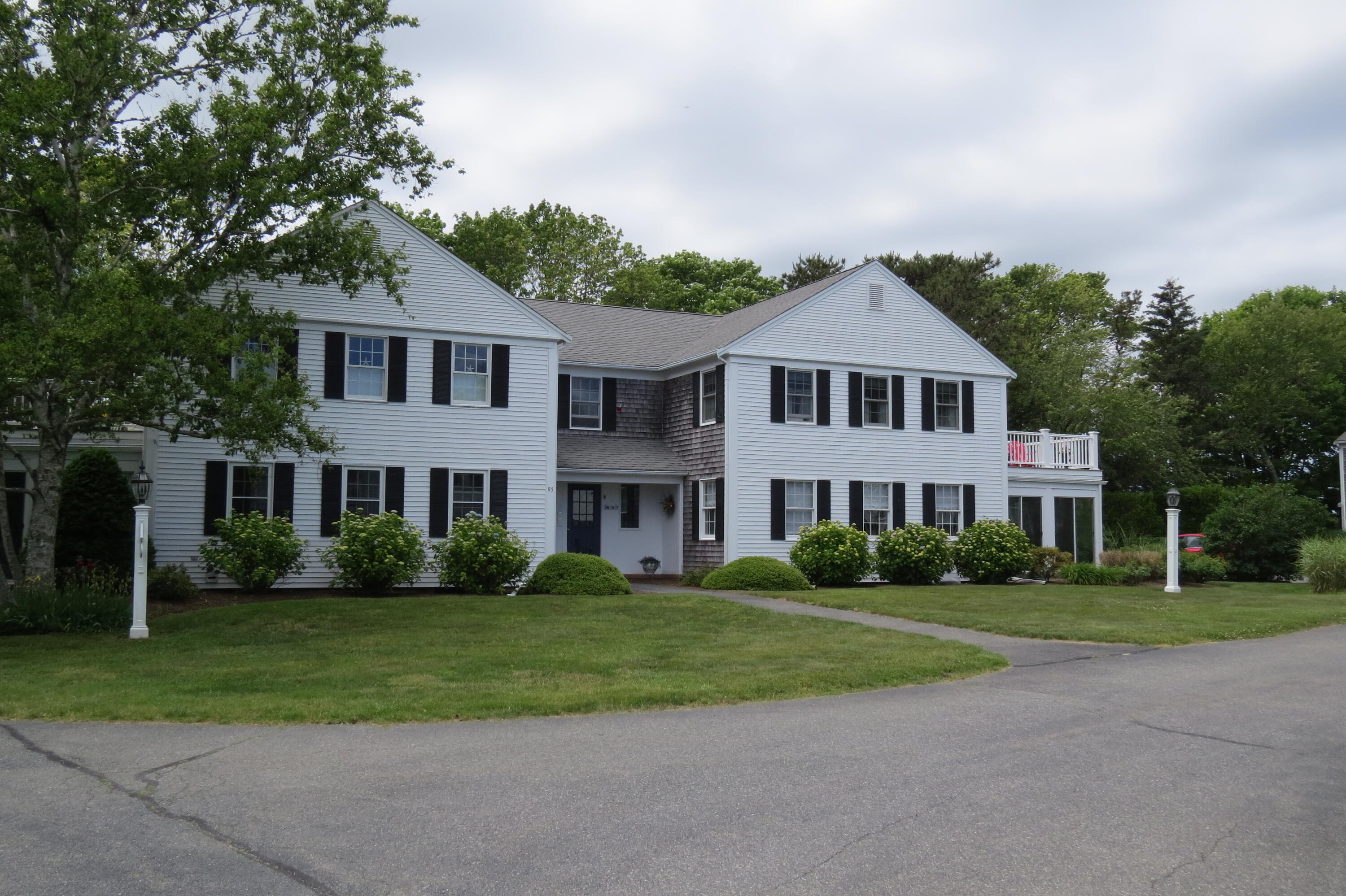 a front view of a house with a garden and trees