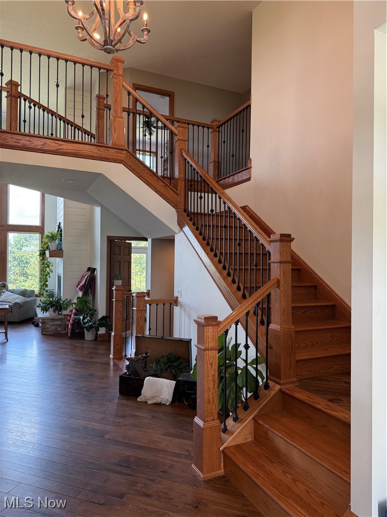 49402 Patton Road Jerusalem, OH 43747 - Photo 7 of 28 Staircase with a towering ceiling, wood-type flooring, and a chandelier