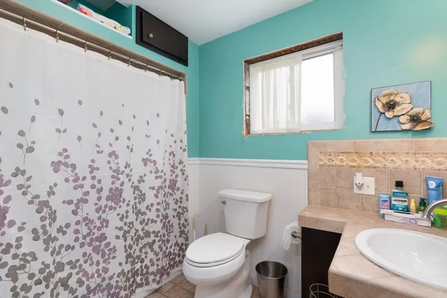 a bathroom with a toilet sink and mirror