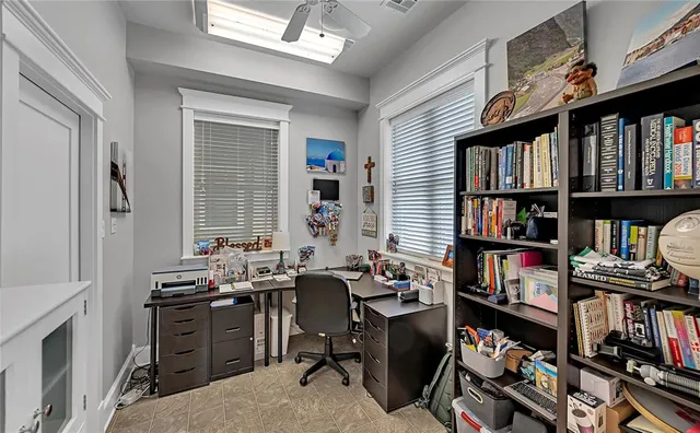 a view of a workspace with furniture and a book shelf