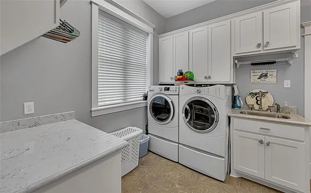 a utility room with sink dryer and washer