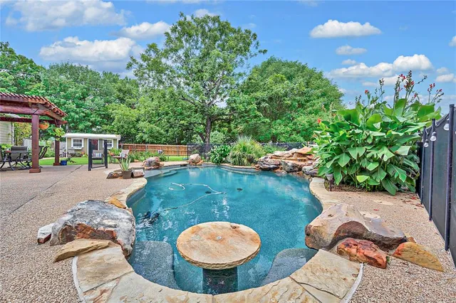 a backyard of a house with table and chairs potted plants