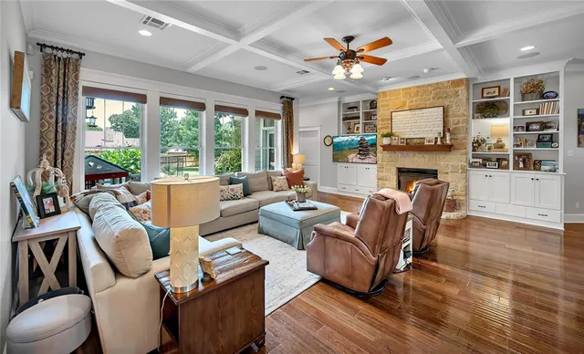 a living room with furniture a fireplace and a large window