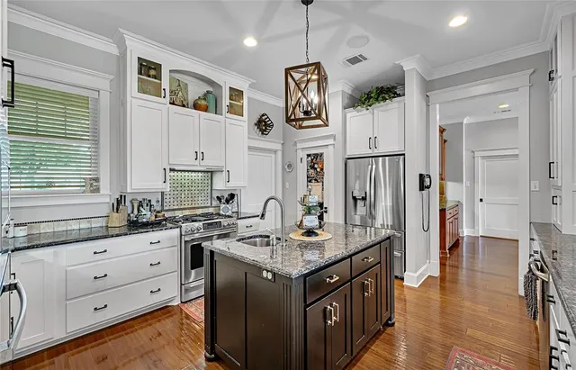 a kitchen with granite countertop a sink stove and refrigerator