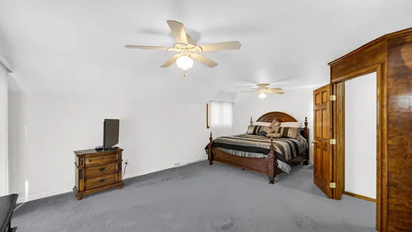 a bedroom with bed and a chandelier