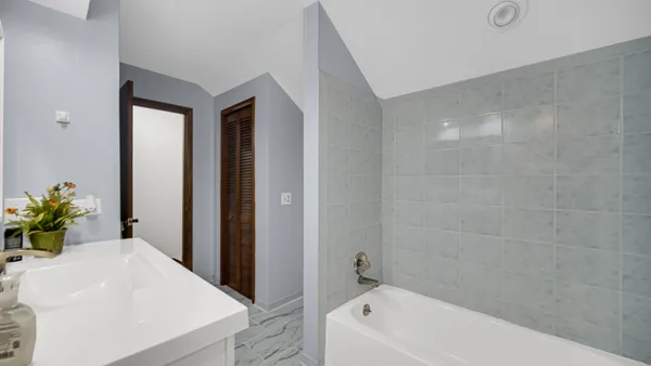 a bathroom with a bathtub a sink a window and a shower