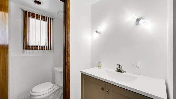 a bathroom with a sink vanity granite toilet and a mirror