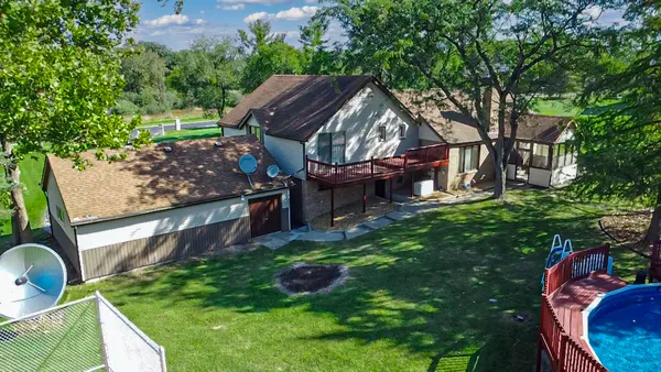 an aerial view of a residential houses with outdoor space and street view