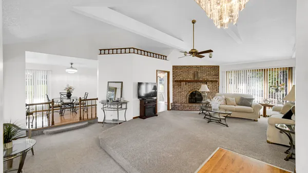 a living room with furniture a fireplace and a chandelier
