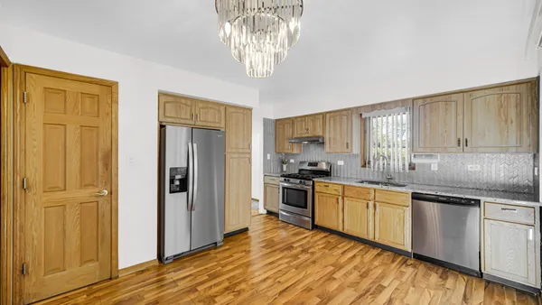 a kitchen with stainless steel appliances granite countertop a refrigerator and a sink