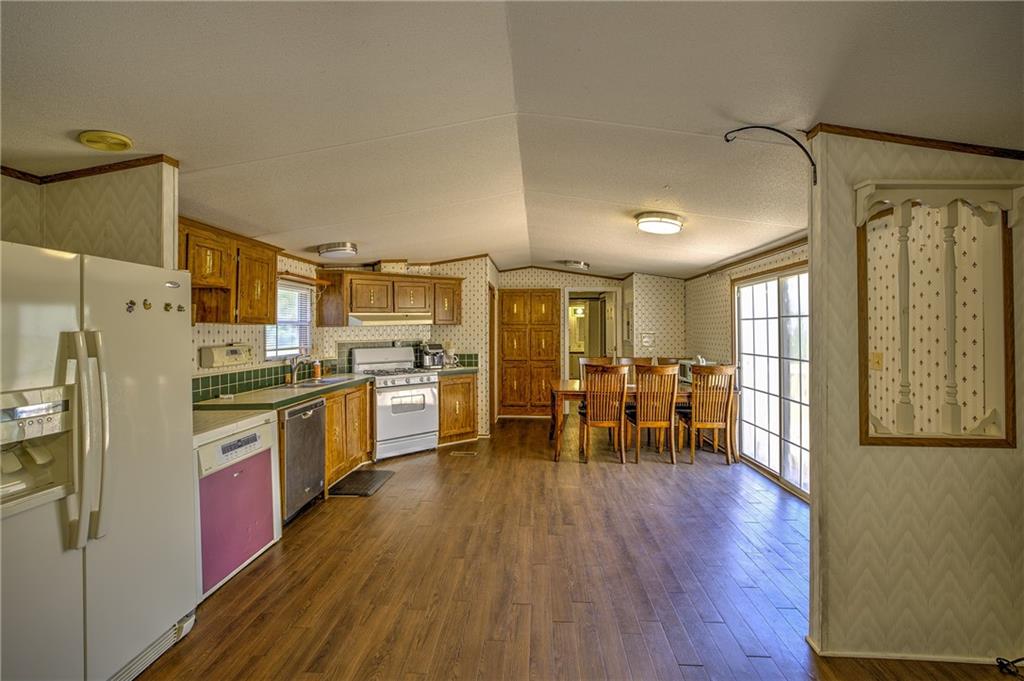 4201 Dunagan Road Gainesville, GA 30507 - Photo 16 of 37 a kitchen with stainless steel appliances a refrigerator a stove a dining table and chairs with wooden floor