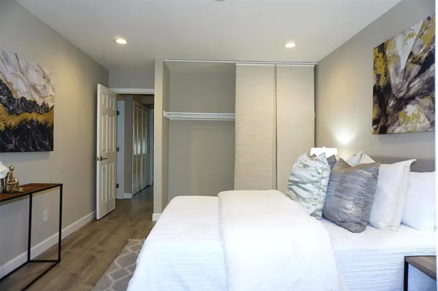 a bedroom with a large bed and a painting on the wall