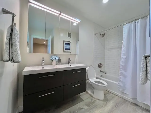 a bathroom with a double vanity sink mirror double and toilet