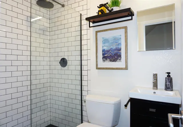a bathroom with a toilet a sink and mirror