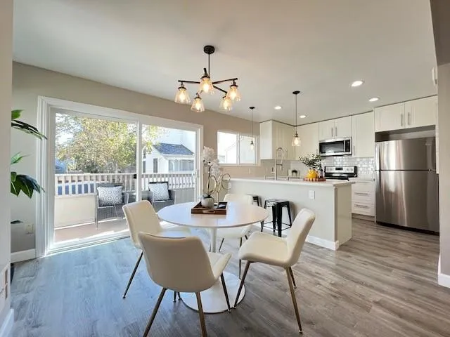 a dining room with furniture a chandelier and wooden floor