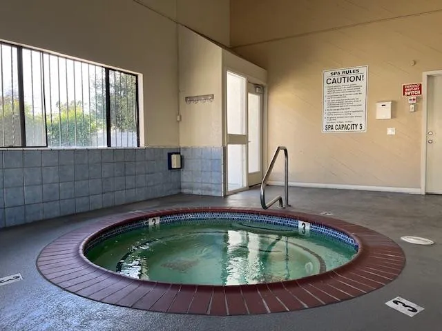 a small pool with lawn chairs and wooden floor