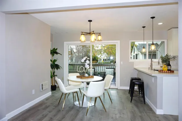 a dining room with furniture a chandelier and wooden floor