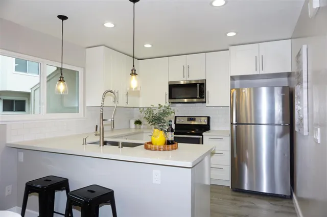 a kitchen with a sink a counter space appliances and cabinets