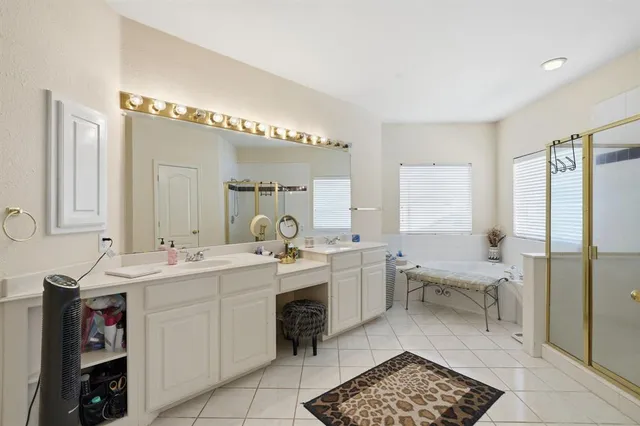 a spacious bathroom with a double vanity sink mirror and a bathtub