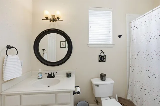 a bathroom with a sink mirror toilet and a mirror