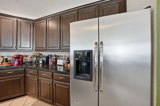 a kitchen with stainless steel appliances granite countertop a refrigerator and cabinets